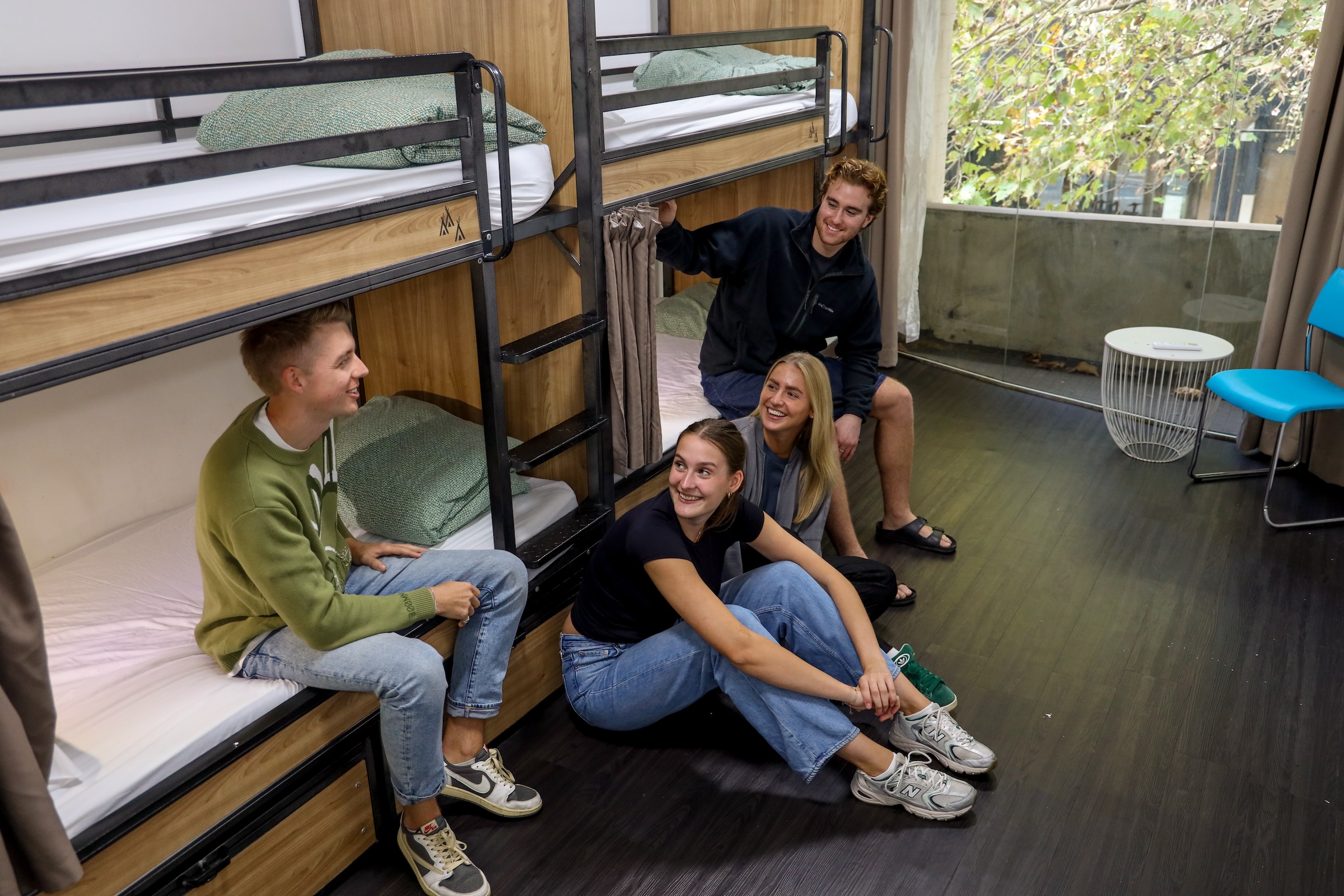 People sitting in a 4 bed dorm room in sydney hostel